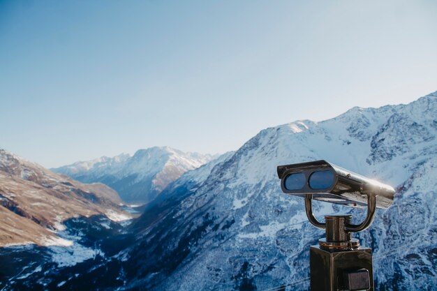 Binocolo sul ponte di osservazione nel primo piano delle montagne.