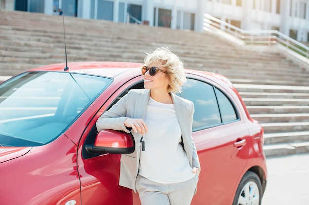 Bionda attraente in un'auto che mostra le chiavi