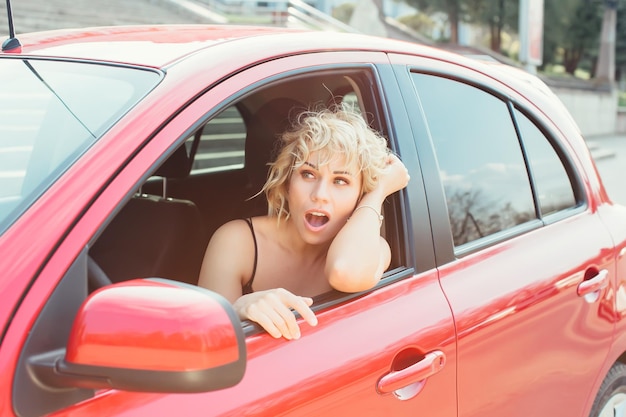 Bionda attraente in un'auto che mostra le chiavi