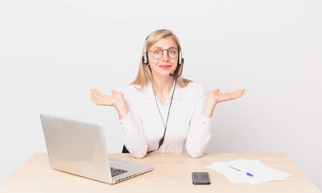 Bionda bella donna giovane donna bionda sentirsi perplessa e confusa e dubitando e lavorando con un laptop