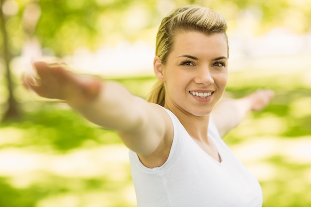 Bionda pacifica che fa yoga nel parco