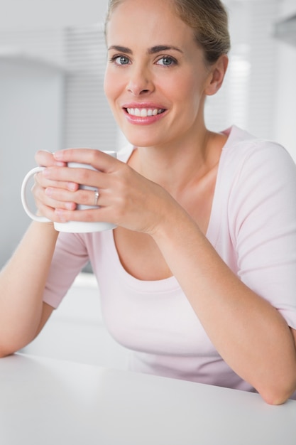 Bionda radiosa che mangia caffè