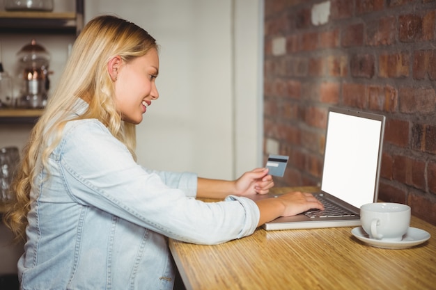 Bionda sorridente che fa spesa online