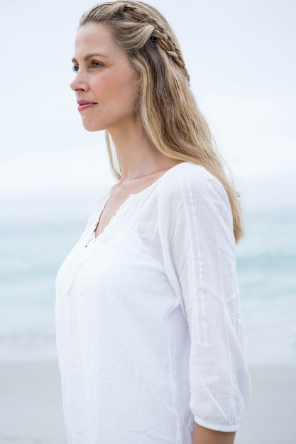 Bionda sorridente che fa una pausa il mare