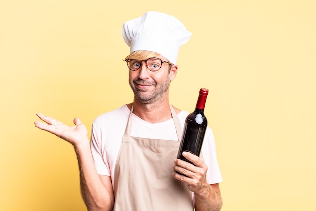 biondo bello chef uomo adulto con in mano una bottiglia di vino