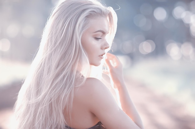 biondo capelli lunghi natura estate / felice ragazza adulta con lo sviluppo nel vento lunghi capelli biondi nel campo estivo