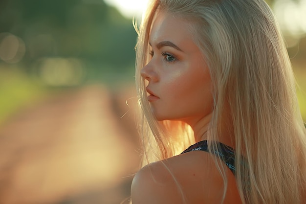 biondo capelli lunghi natura estate / felice ragazza adulta con lo sviluppo nel vento lunghi capelli biondi nel campo estivo