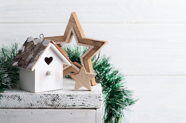 Birdhouse di Pentecoste della decorazione interna di Natale e stelle sulla superficie rustica bianca con lo spazio della copia