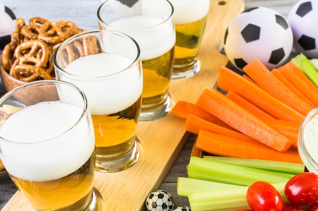 Birra alla spina e snack salati sul tavolo per la festa di calcio.