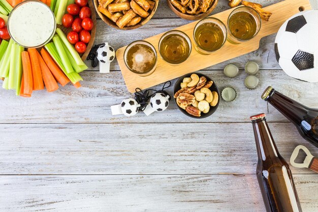 Birra alla spina e snack salati sul tavolo per la festa di calcio.