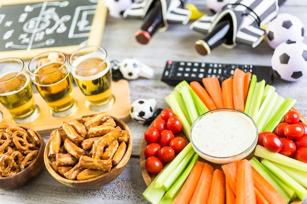 Birra alla spina e snack salati sul tavolo per la festa di calcio.