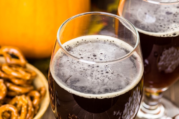 Birra artigianale alla zucca in bicchieri da birra con salatini salati e popcorn.