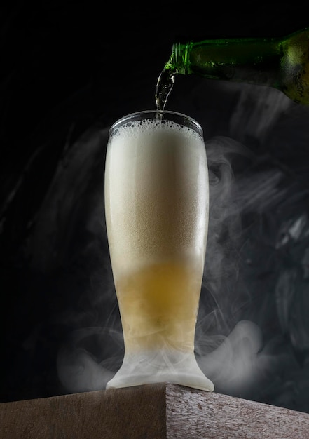 Birra che si versa nella tazza in un bar Scrivania in legno e sfondo grigio