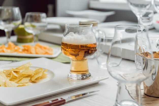 Birra e patatine fritte su un grande tavolo bianco