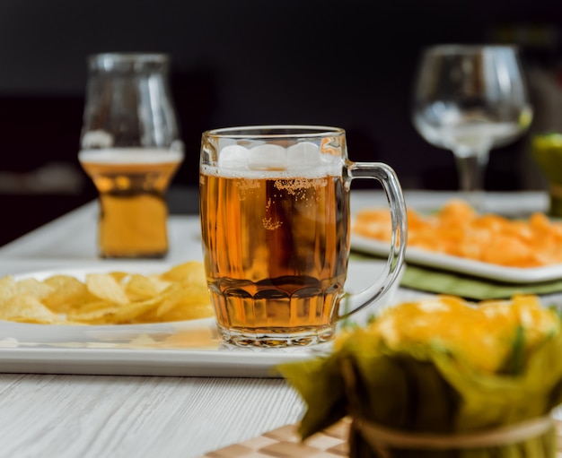 Birra e patatine fritte su un grande tavolo bianco