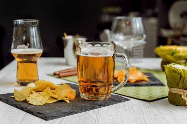 Birra e patatine fritte su un grande tavolo bianco