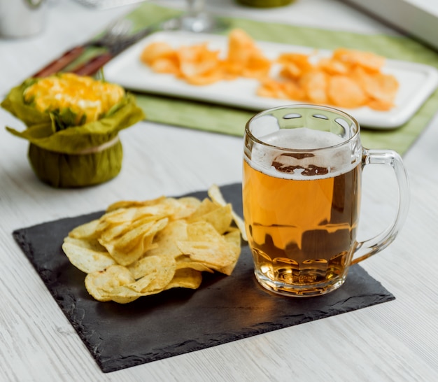 Birra e patatine fritte su un grande tavolo bianco