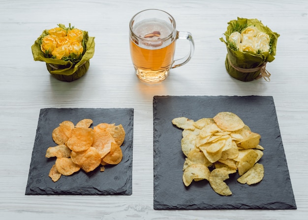 Birra e patatine fritte sul grande tavolo bianco