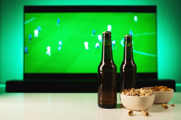 Birra e snack ambientati sullo sfondo della partita di calcio in tv