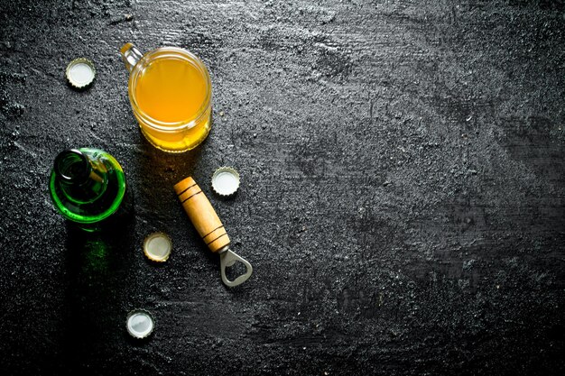 Birra in un bicchiere e una bottiglia di vetro aperta con apri
