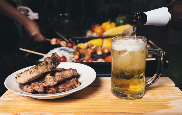 Birra versando con griglia di maiale barbecue