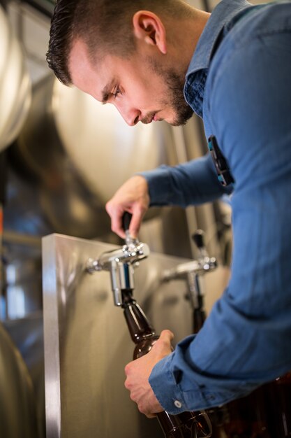 Birraio riempiendo birra in bottiglia