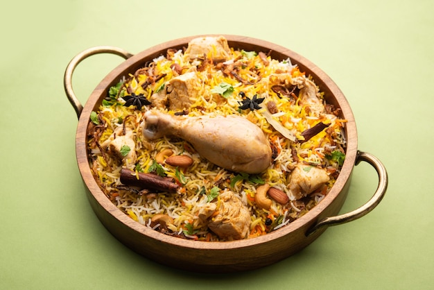 Biryani di pollo piccante in stile ristorante servito con Raita e Salan, cibo popolare indiano o pakistano non vegetariano?