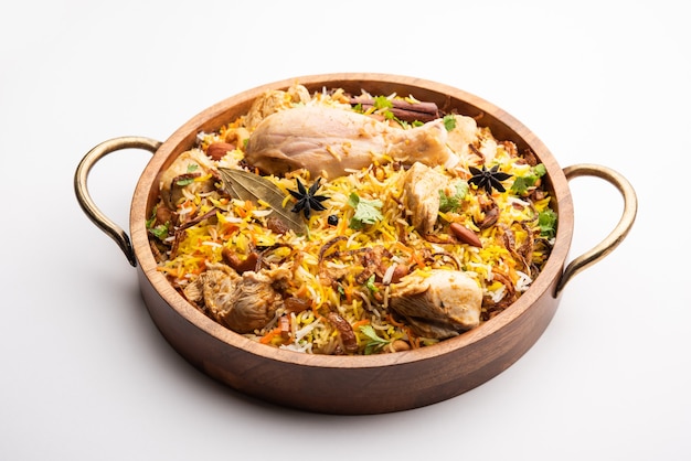 Biryani di pollo piccante in stile ristorante servito con Raita e Salan, cibo popolare indiano o pakistano non vegetariano?