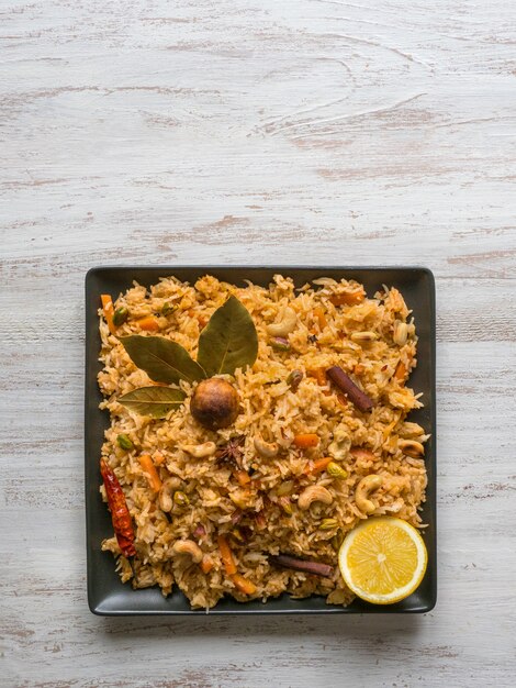 Biryani di verdure, piatto vegetariano su un tavolo nero. Vista dall'alto, copia spazio