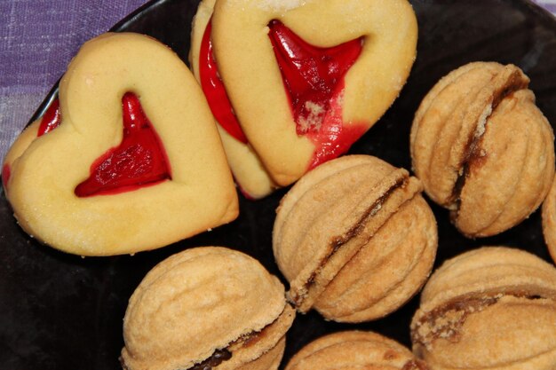 Biscotti a cuore e noci Pasticceria a forma di cuore e capanne con ripieno dolce Dolci dolci