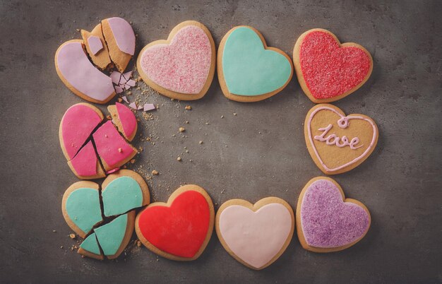 Biscotti a forma di cuore colorati gustosi su sfondo grigio