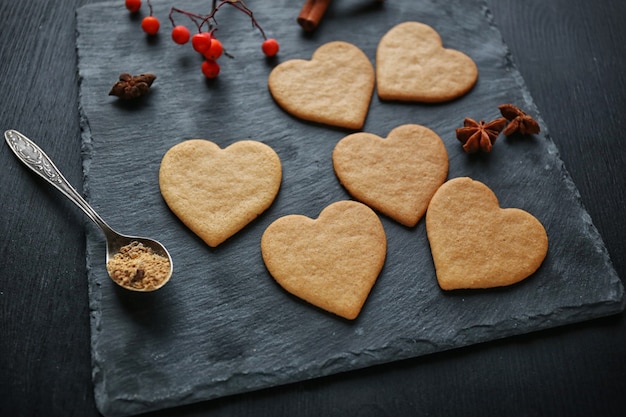 Biscotti a forma di cuore con bacche di cenere su un tappetino