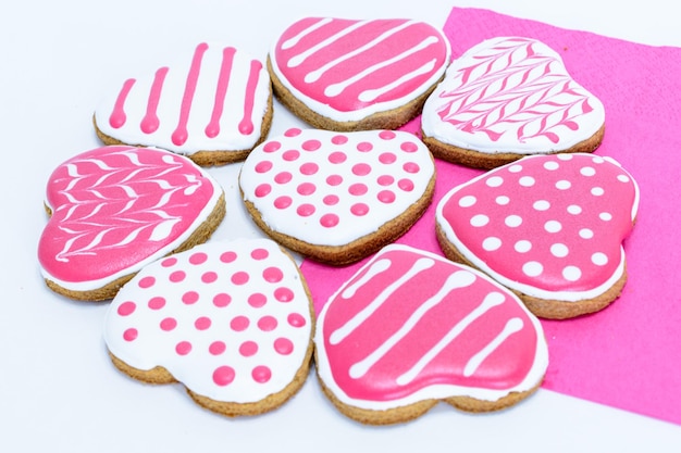 biscotti a forma di cuore con punti e strisce su sfondo bianco e rosa, macro