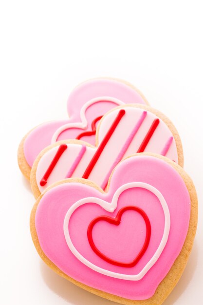 Biscotti a forma di cuore decorati con fantasia di glassa.