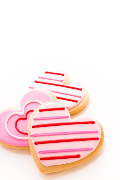 Biscotti a forma di cuore decorati con fantasia di glassa.