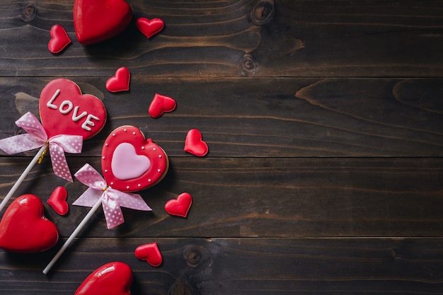 Biscotti a forma di cuore di giorno di biglietti di S. Valentino sul fondo di legno della tavola con lo spazio della copia.