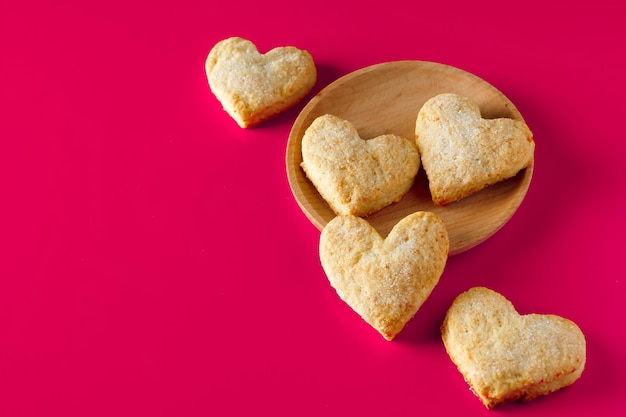 Biscotti a forma di cuore per San Valentino su sfondo rosa