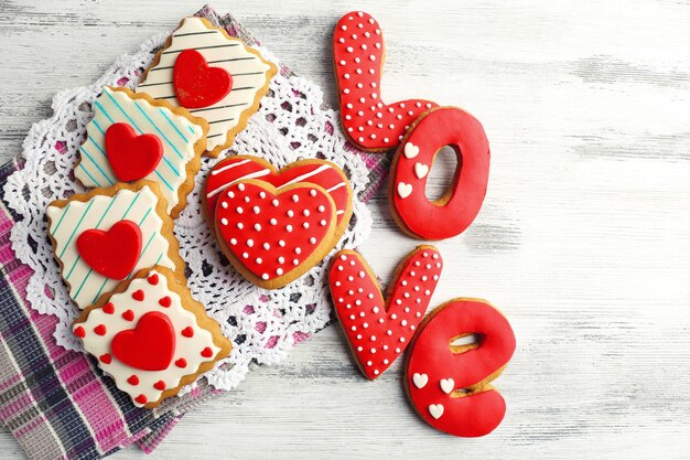 Biscotti a forma di cuore per San Valentino sul tovagliolo, su fondo in legno colorato