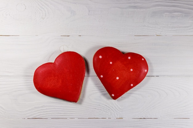 Biscotti a forma di cuore per San Valentino sulla tavola di legno bianca. Vista dall'alto, copia spazio