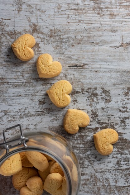Biscotti a forma di cuore su fondo rustico chiaro