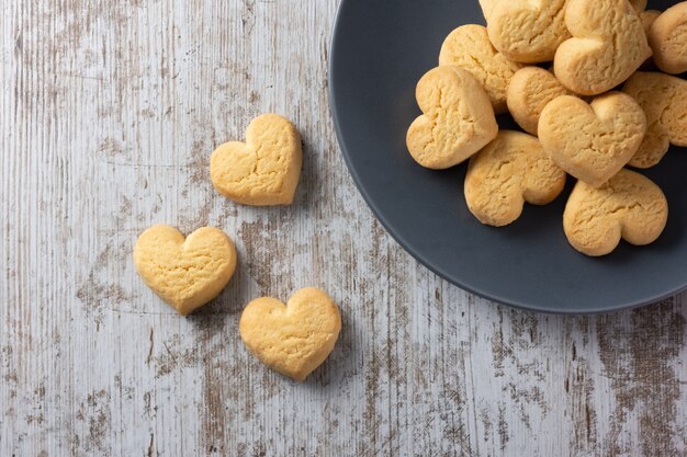 Biscotti a forma di cuore su fondo rustico chiaro