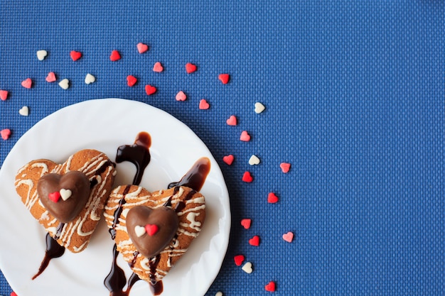 Biscotti a forma di cuore su un piccolo piatto bianco