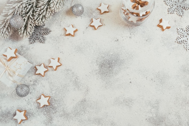 Biscotti a forma di stella e decorazioni natalizie su sfondo bianco. Concetto di vacanze invernali. Vista dall'alto, spazio libero per il testo