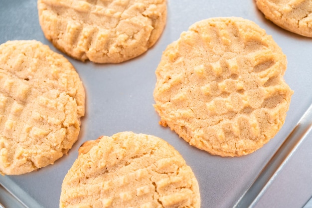 Biscotti al burro di arachidi appena sfornati su una teglia.