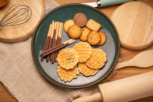 Biscotti al burro fatti in casa e biscotti con scaglie di cioccolato e biscotti con bastoncini su fondo di legno