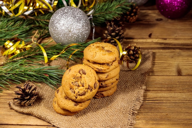 Biscotti al cioccolato con decorazioni natalizie su tavola di legno