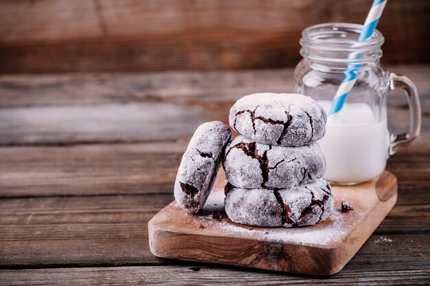 Biscotti al cioccolato con glassa di zucchero a velo per natale su fondo di legno