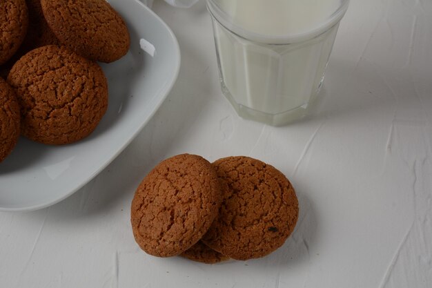 Biscotti al cioccolato con latte su sfondo bianco