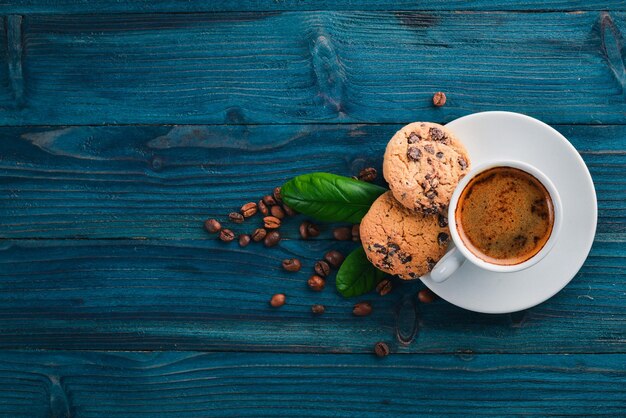 Biscotti al cioccolato di farina d'avena e caffè su un fondo di legno. Chicchi di caffè. Vista dall'alto. Spazio libero per il testo.