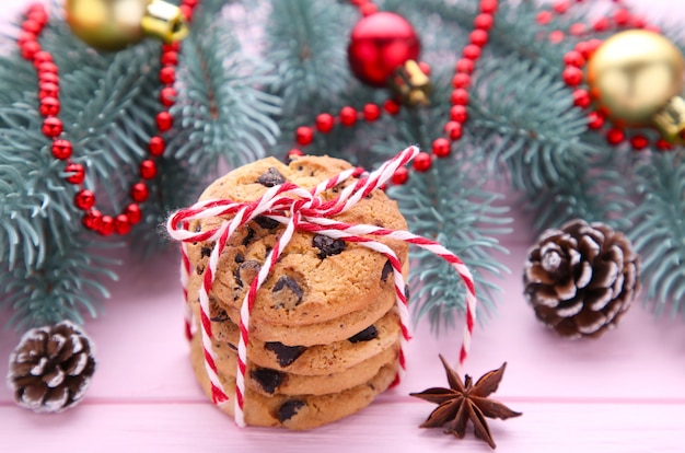 Biscotti al cioccolato e decorazione di natale su di legno rosa